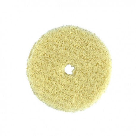Round yellow scrubber pad on a white background