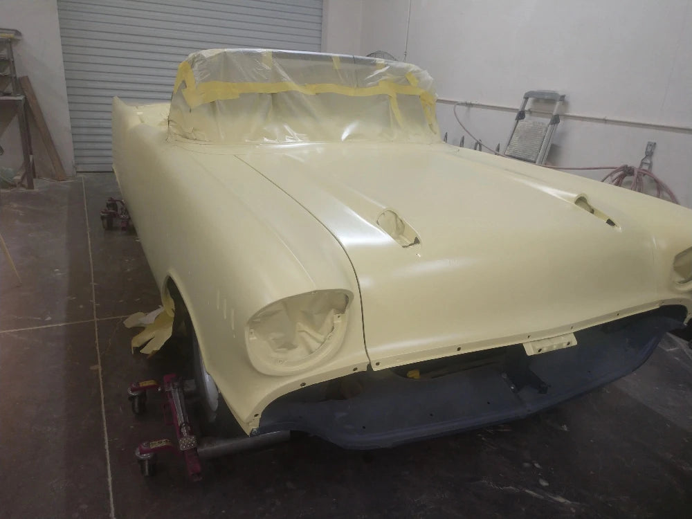Partial view of a vintage car body on a lift in a garage