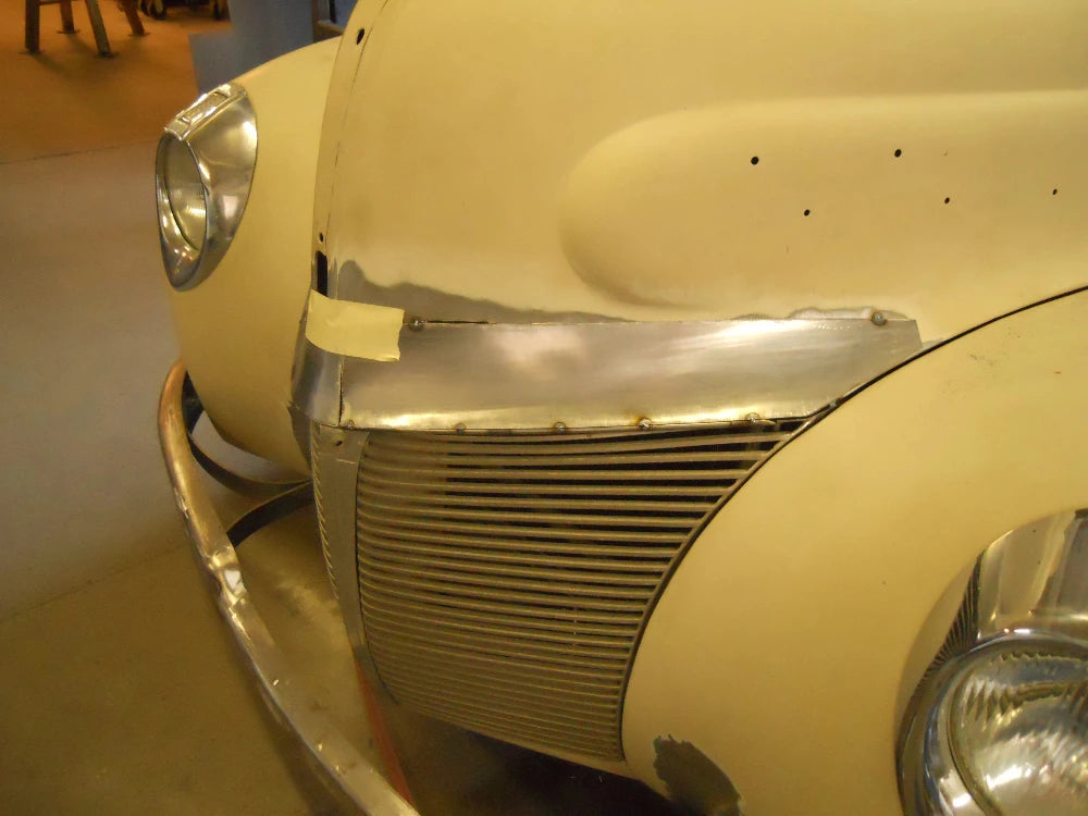 Close-up of a vintage car's front grille and headlight