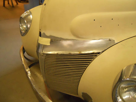 Close-up of a vintage car's front grille and headlight